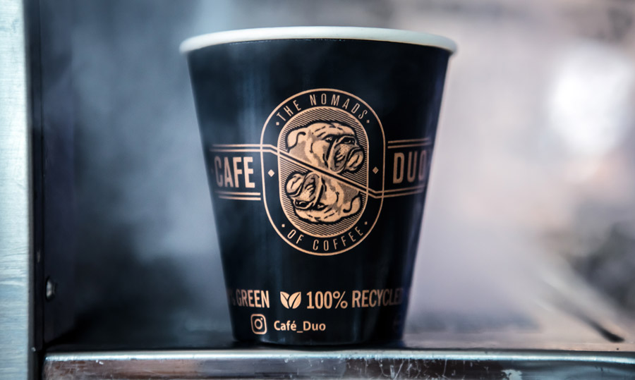 A freshly prepared Café Duo coffee in a recyclable branded cup
