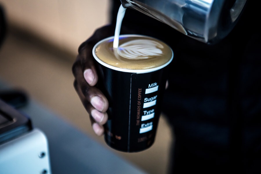 A Café Duo barista pouring latte art